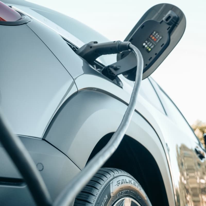 Nahaufnahme eines Elektroautos während des Ladevorgangs mit Ladekabel