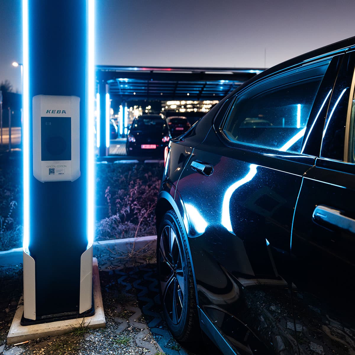 Elektrofahrzeug beim Laden an einer modernen Ladesäule mit Solardach
